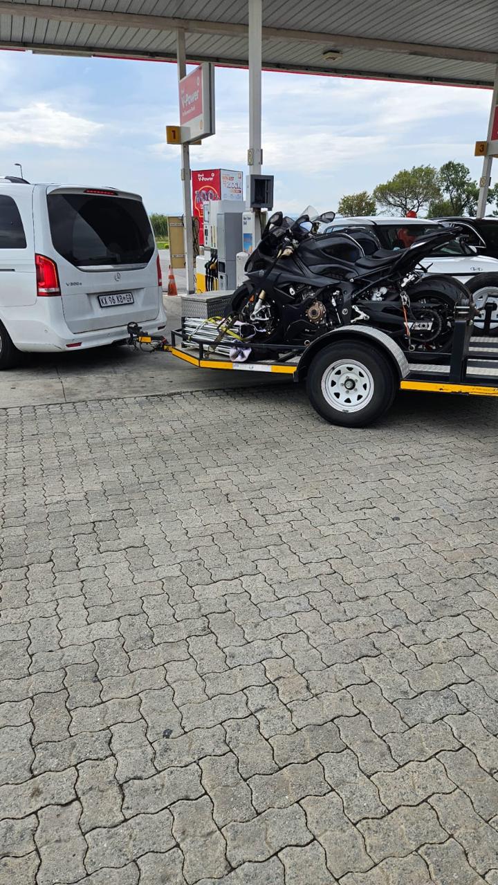 Black BMW S1000RR strapped to a trailer at a Shell fuel station